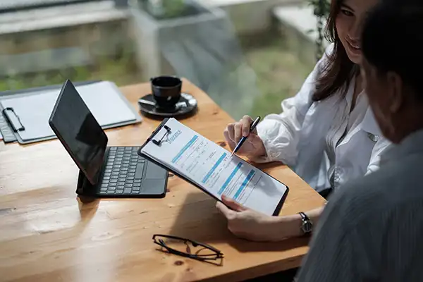 A receptionist at Chicago Oral Surgery and Implant Center helping a patient fill out a form.