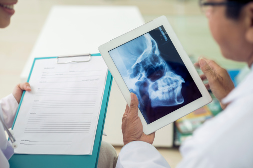 A woman being given a form by the receptionist at Chicago Oral Surgery and Implant Center.